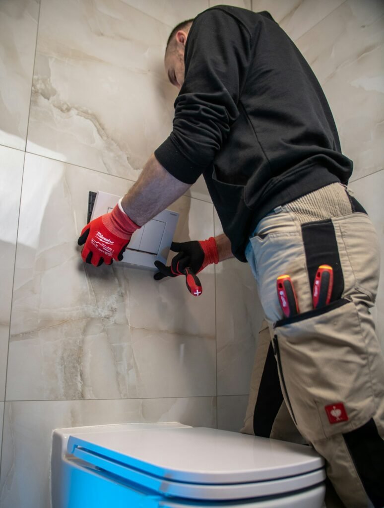 Plumber repairing a toilet in a Dubai bathroom